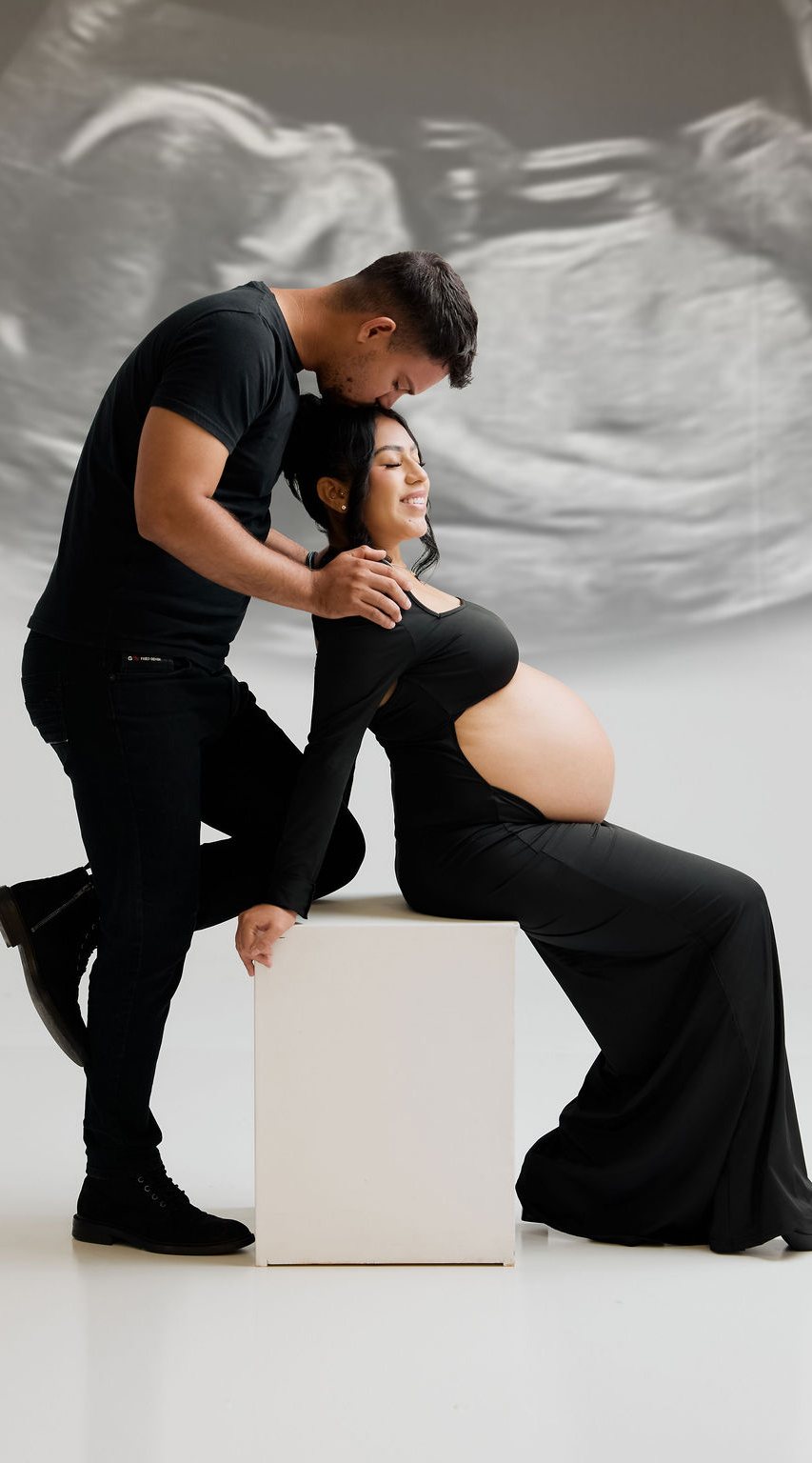 Expecting couple in studio with an ultrasound backdrop