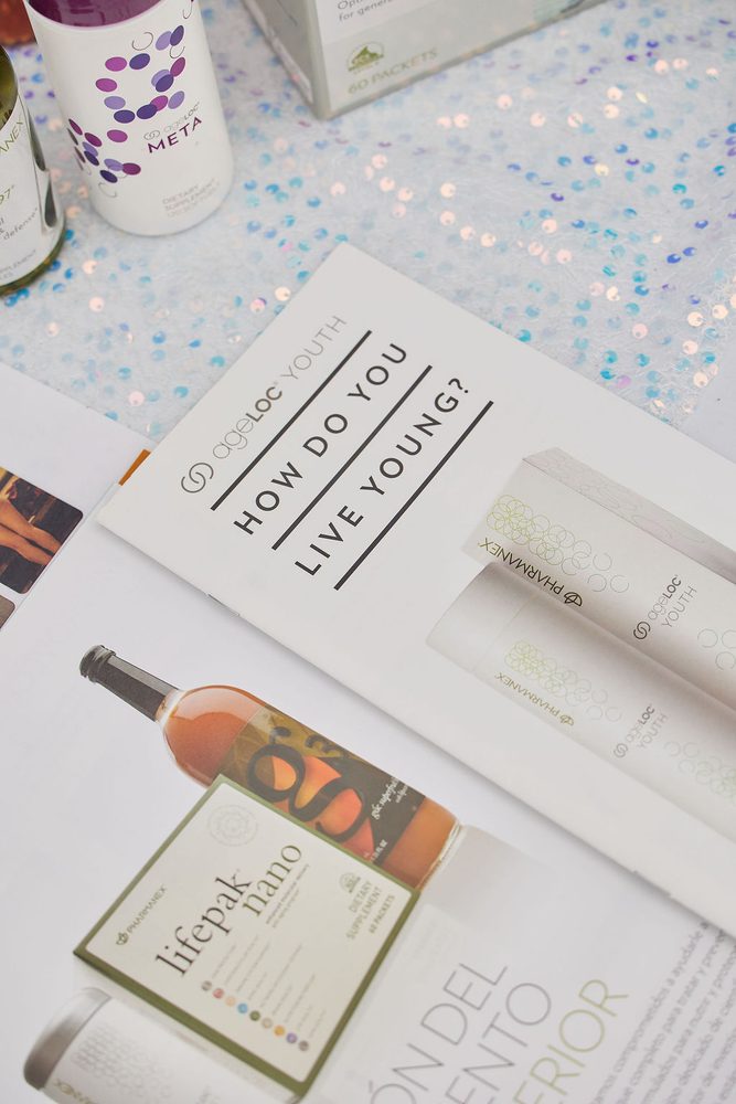 Wellness supplement brochures and bottles laid out on an iridescent sequined tablecloth