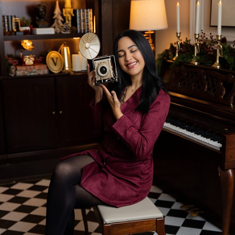 Veronica Touma con una camara de fuelle junto al piano