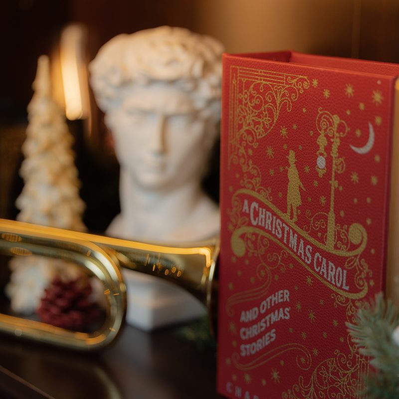 Libro navideno y trompeta dorada sobre el piano